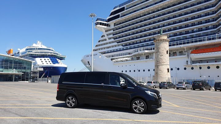 Black Mercedes V-Class parked at the cruise terminal beside a berthed cruise ship